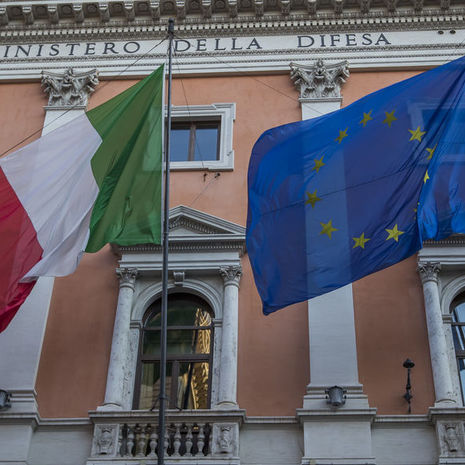 Image of the Italian and European flags on a building.