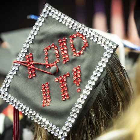A student’s graduation cap with “I did it!” written in rhinestones. 