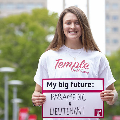 McKenna Burkhardt holding a sign that says "My Big Future: Paramedic and Lieutenant"