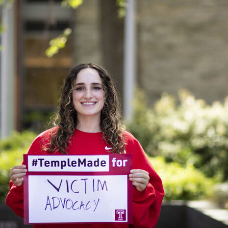 Ray Epstein holding a Temple Made for sign outside of Main Campus