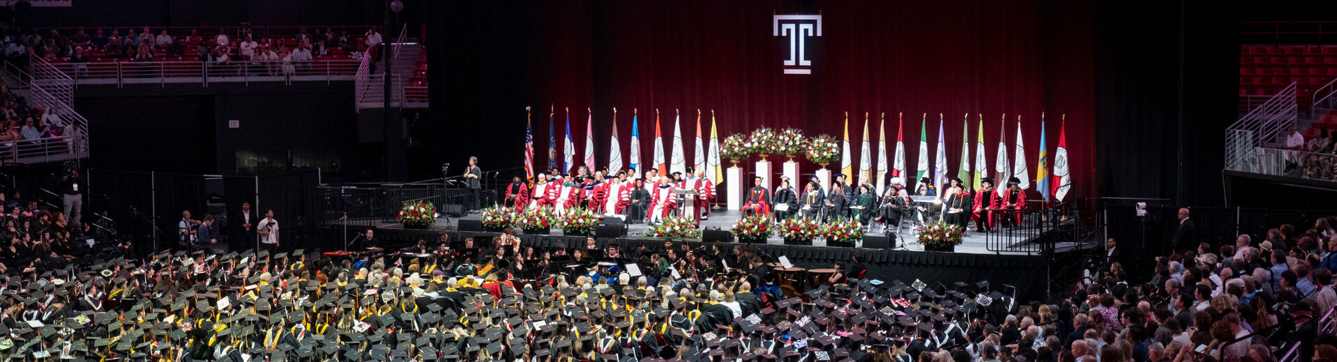 Crowd of graduates and stage party at Commencement ceremony in the Liacouras Center
