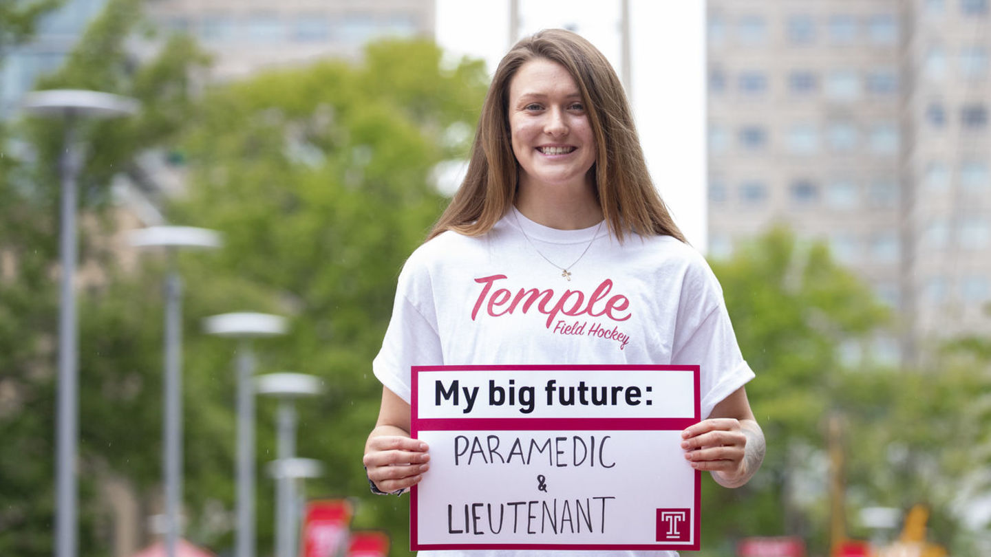 McKenna Burkhardt holding a sign that says "My Big Future: Paramedic and Lieutenant"