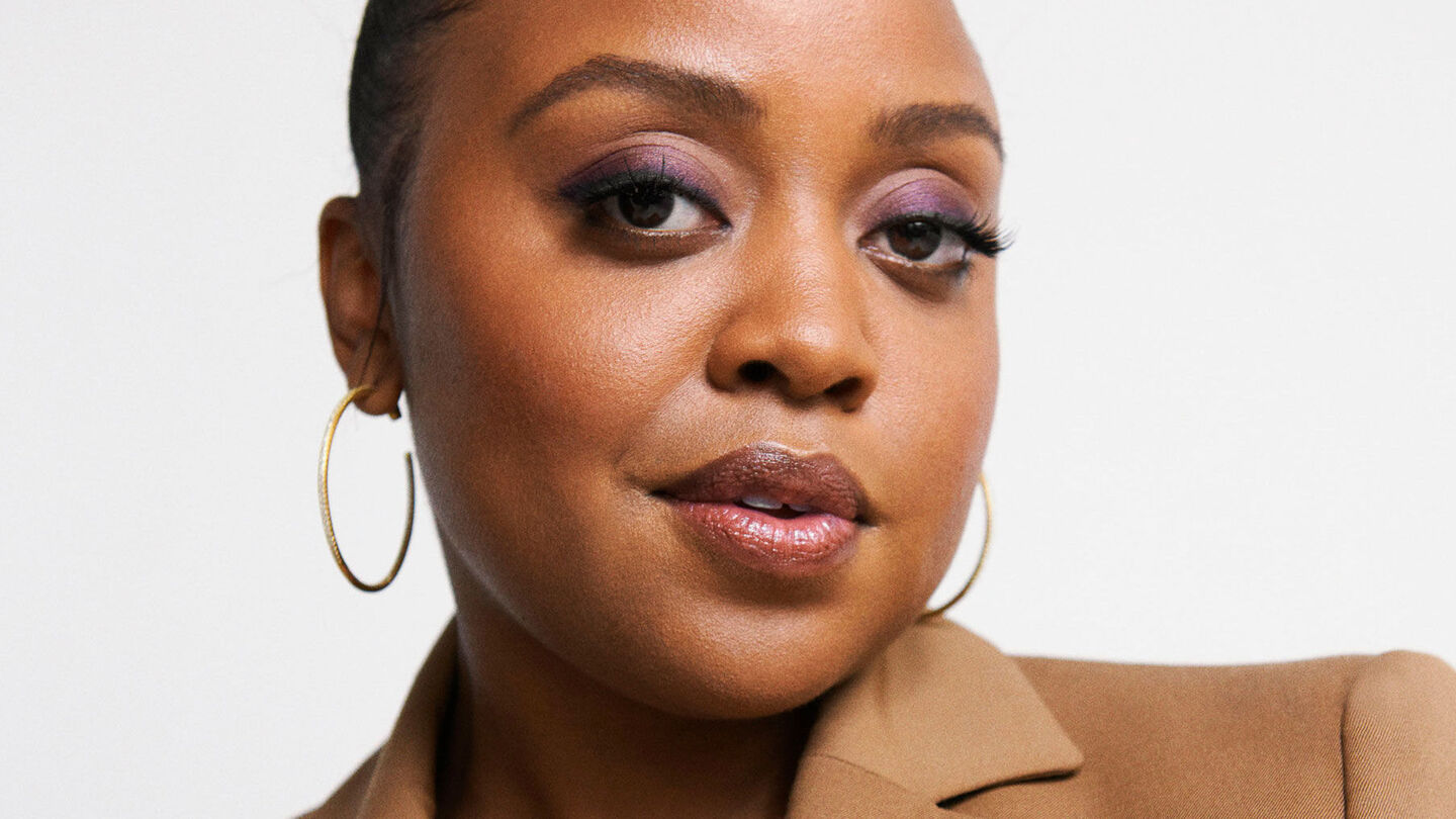 a close up of Quinta Brunson in a tan suit