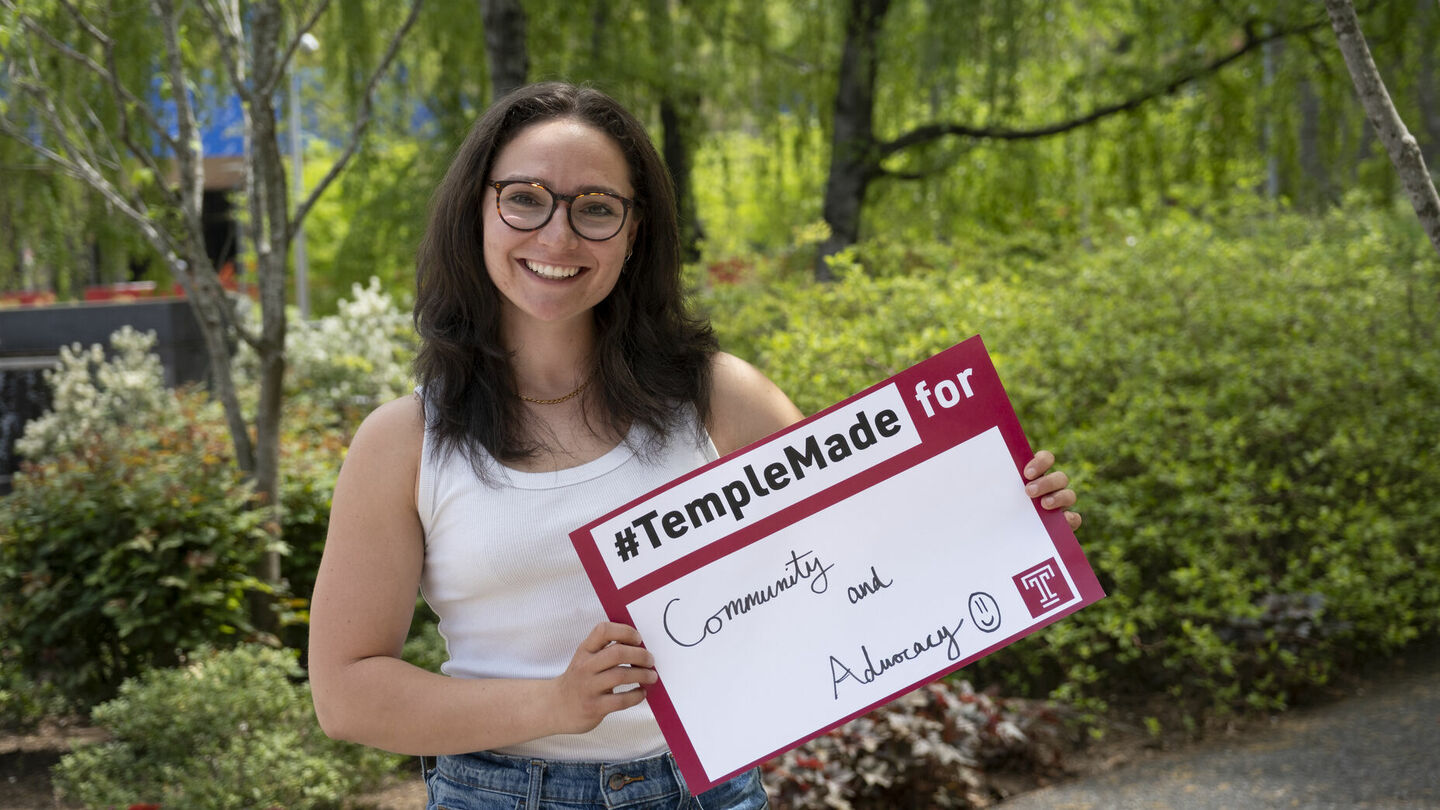 After earning a bachelor’s degree in human development and community engagement, Trista Mayo will pursue a master’s degree in counseling psychology at Temple. Trista Mayo standing outside holding up a Temple Made for sign